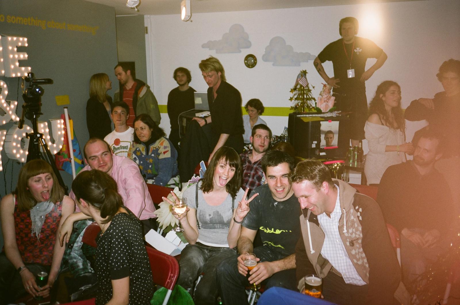A packed audience sits and stands close together inside the talk-show studio.