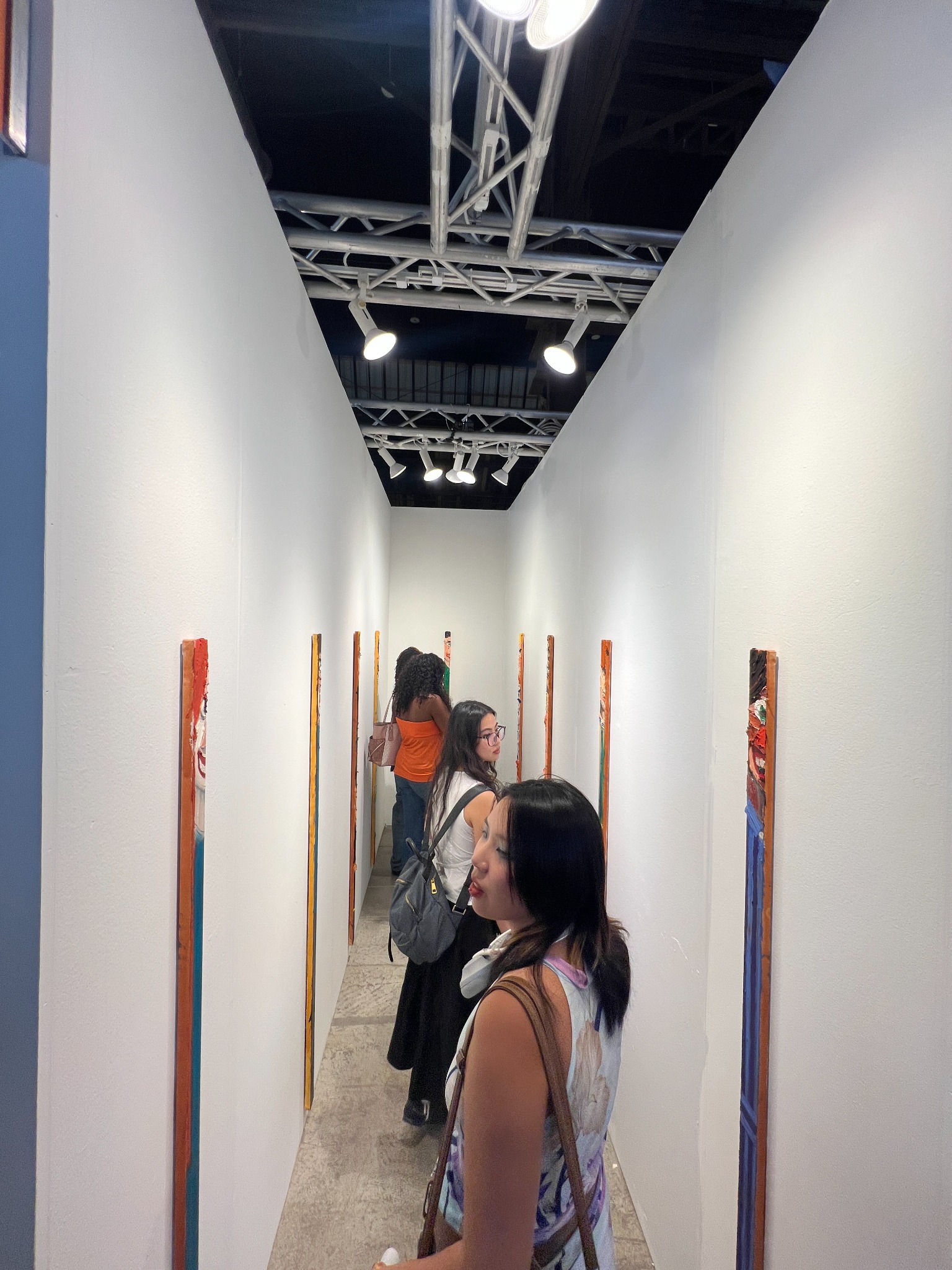 Visitors look at the skinny portraits while standing in single file inside the narrow booth.