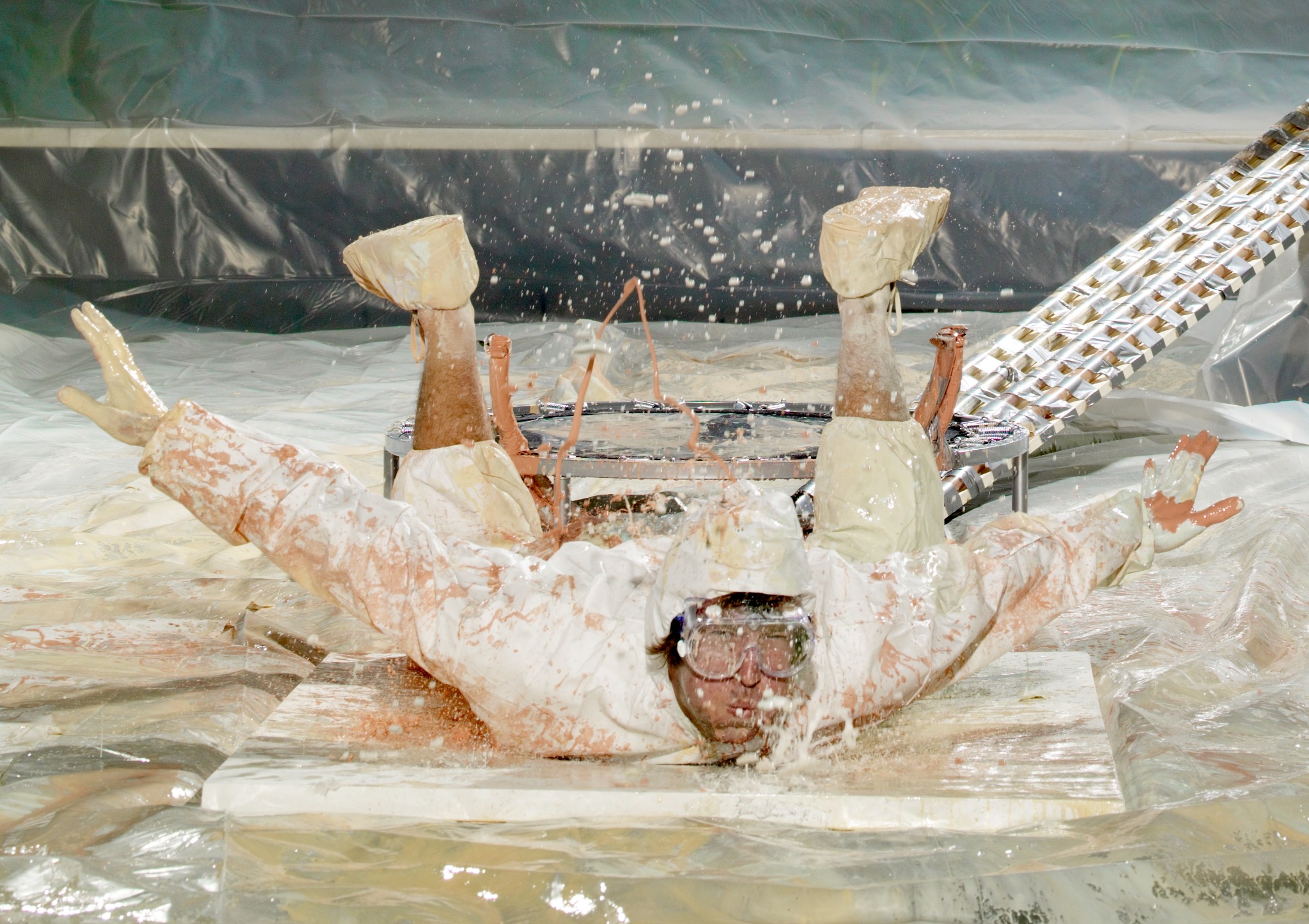 Marc lands face down on a canvas, transferring paint from his white jumpsuit.
